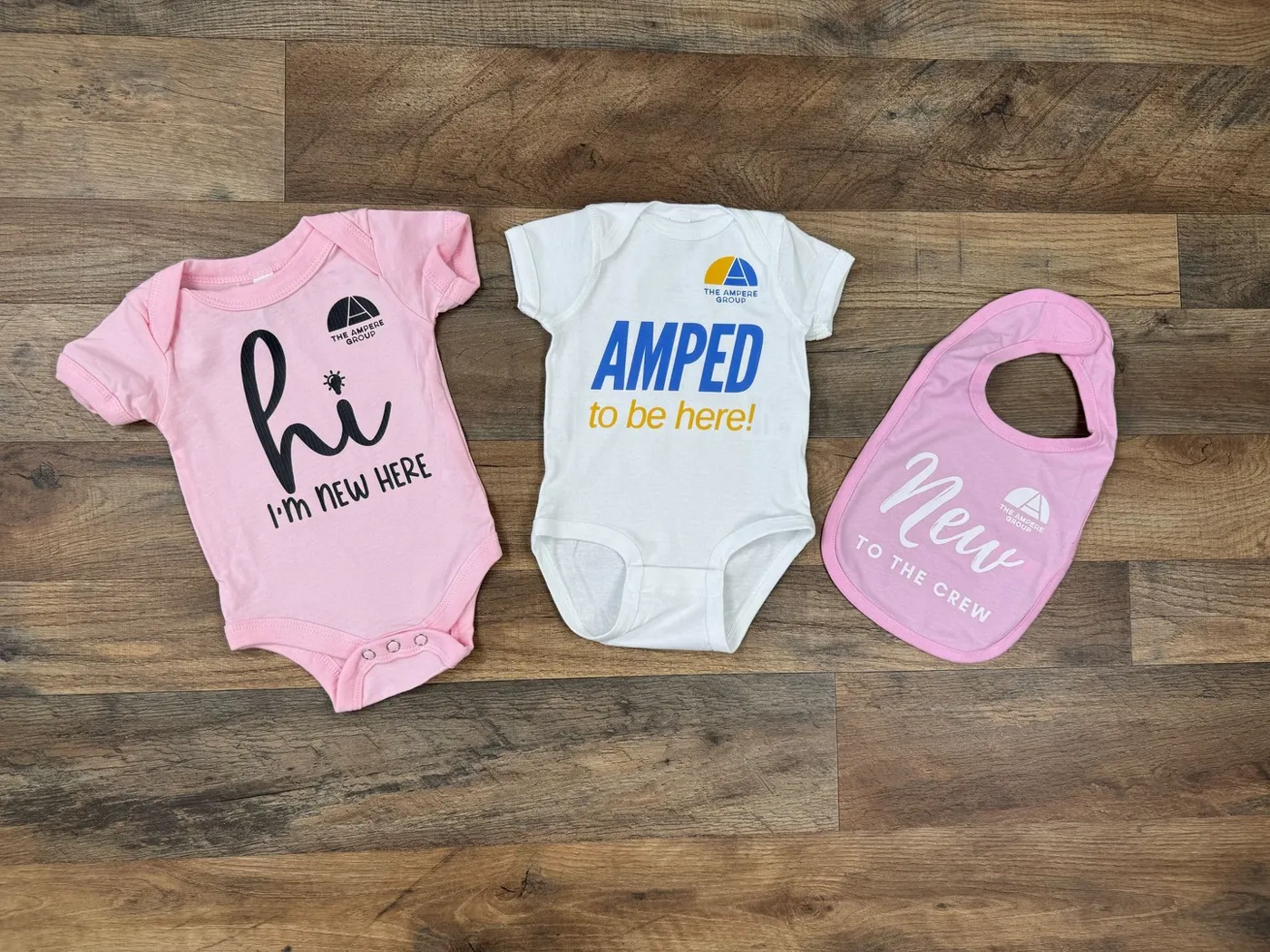 Custom printed baby onesies and bibs made for The Ampere Group by FLO